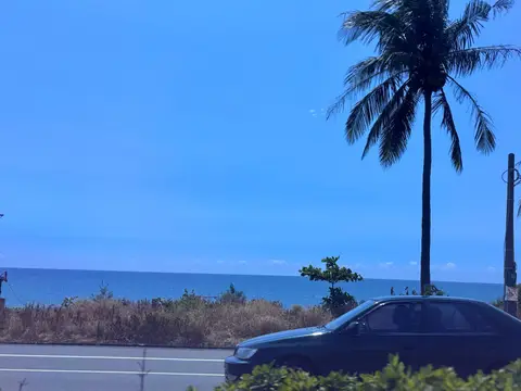 南下恆春途中的海岸公路，一輛車駛過，遠方是海與椰子樹
